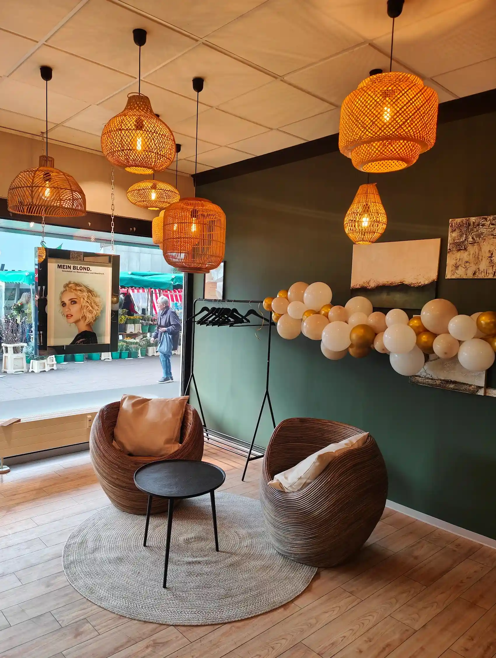 Wartebereich im Salon KAMM & KUNST mit Sesseln und Rattanlampen